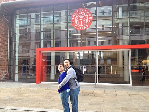 Cory and Omar bonding in front of the glass façade of Shakespeare's Globe Theatre.