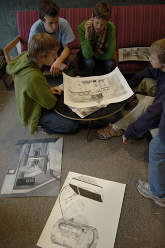 Students participate in a critique for an Observational Drawing course
