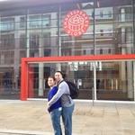 Cory and Omar bonding in front of the glass façade of Shakespeare's Globe Theatre.