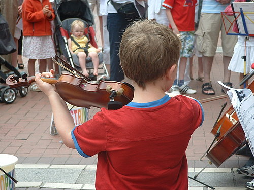 A young violinist plays a solo at the top of Grafton Street.