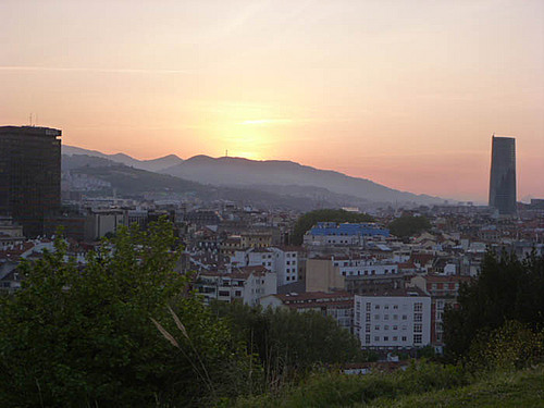 Bilbao: Sunset on hill overlooking city.