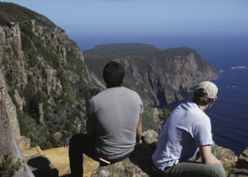 Students sit atop the overlook at Cape Raoul.
