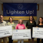 Staff present proceeds from the annual Lighten Up! sale to representatives of local non-profits.