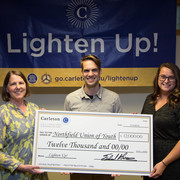 Image of staff members presenting the Northfield Union of Youth with a check for $12,000.