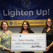 Staff members present a check for $12,000 to Project Friendship.