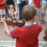 A young violinist plays a solo at the top of Grafton Street.